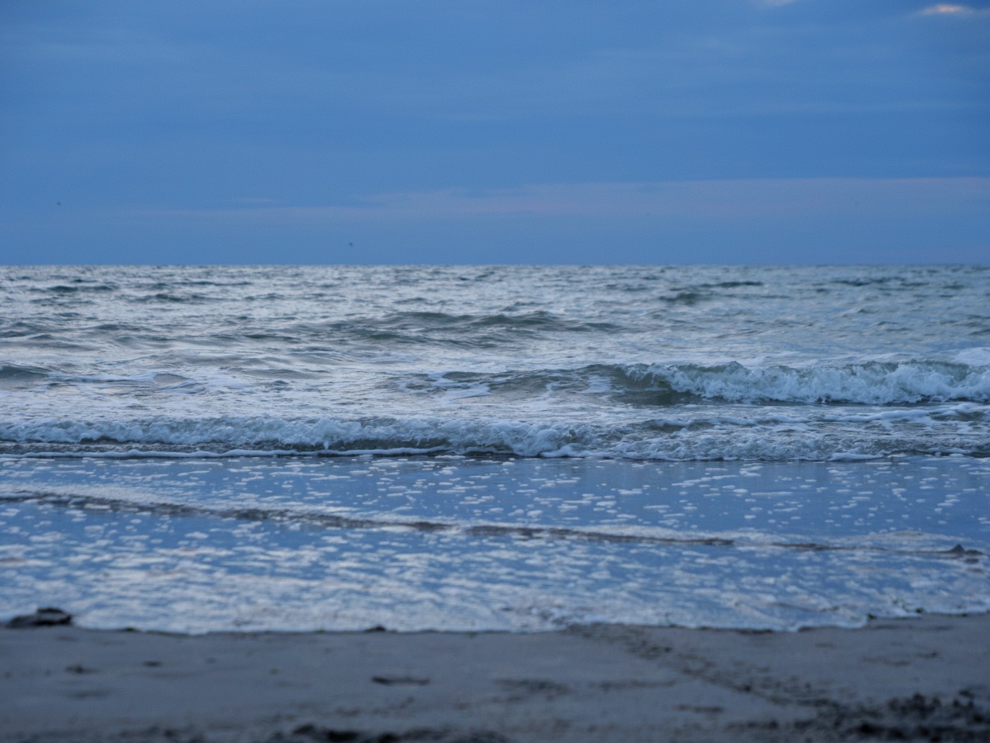 Mer calme sur une plage le soir.